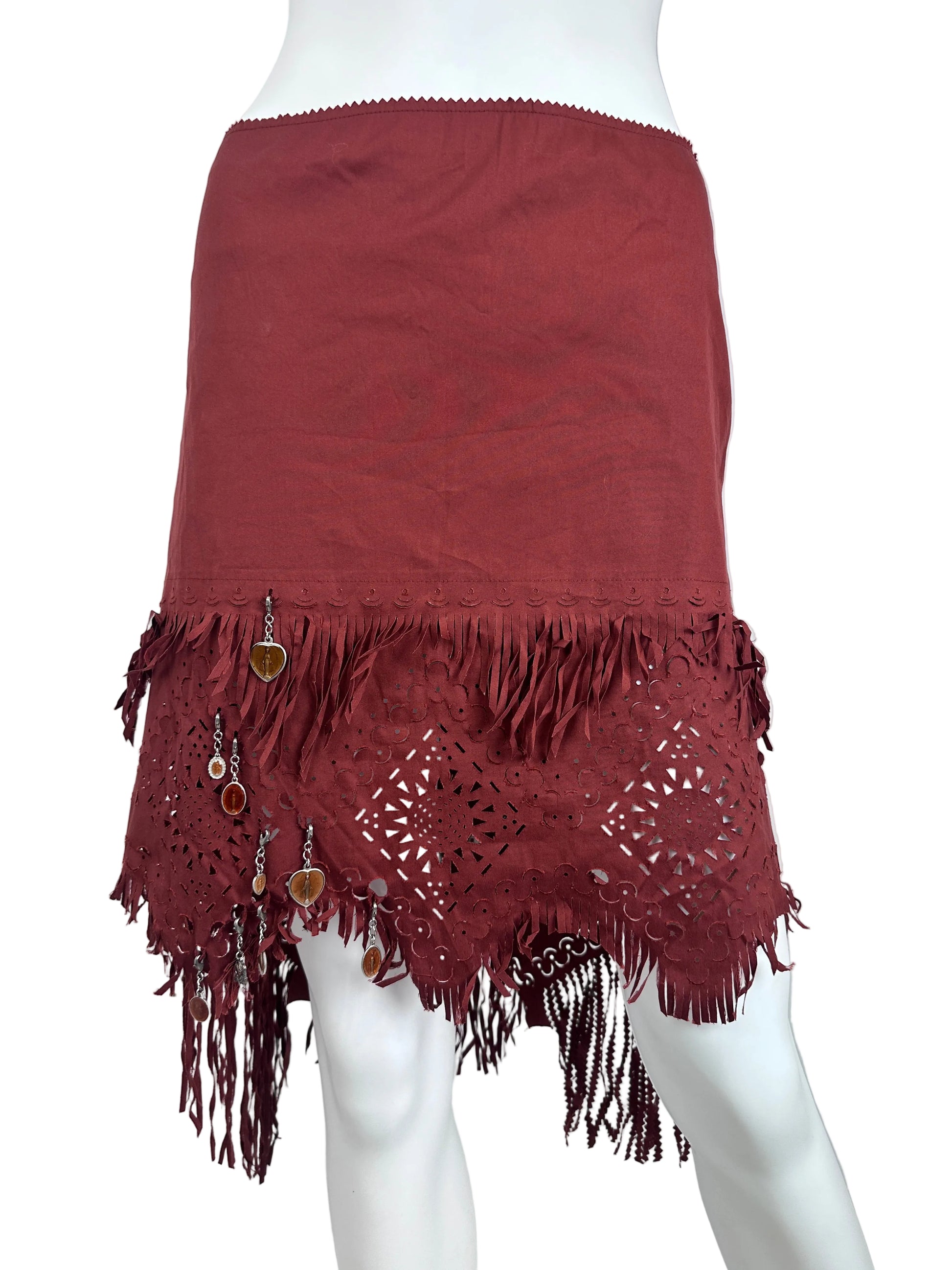 A rust-colored sleeveless skirt with a wide fringed crochet lace hem, displayed on a white mannequin torso against a white background.