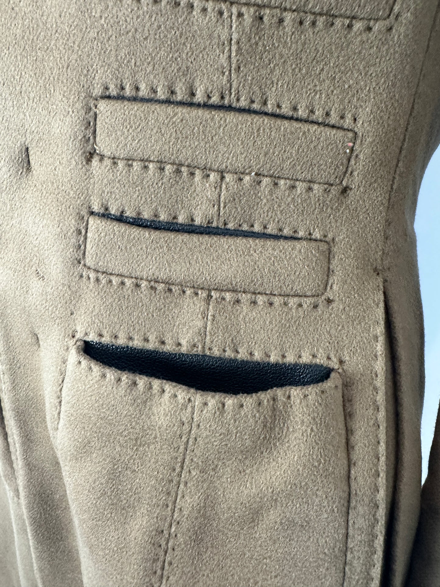 Close-up of a textured beige surface with stitching details