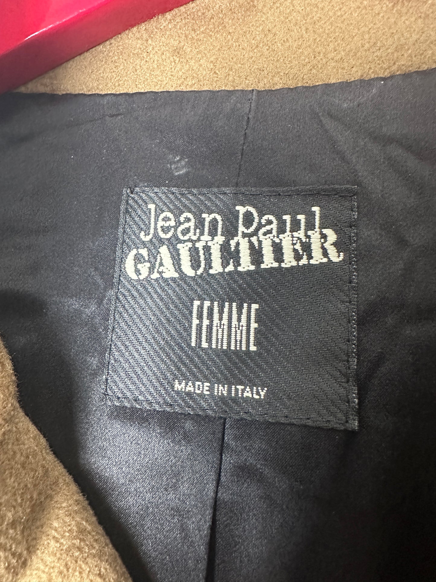 Close-up of a Jean Paul Gaultier label on a garment with 'Femme' and 'Made in Italy' text.
