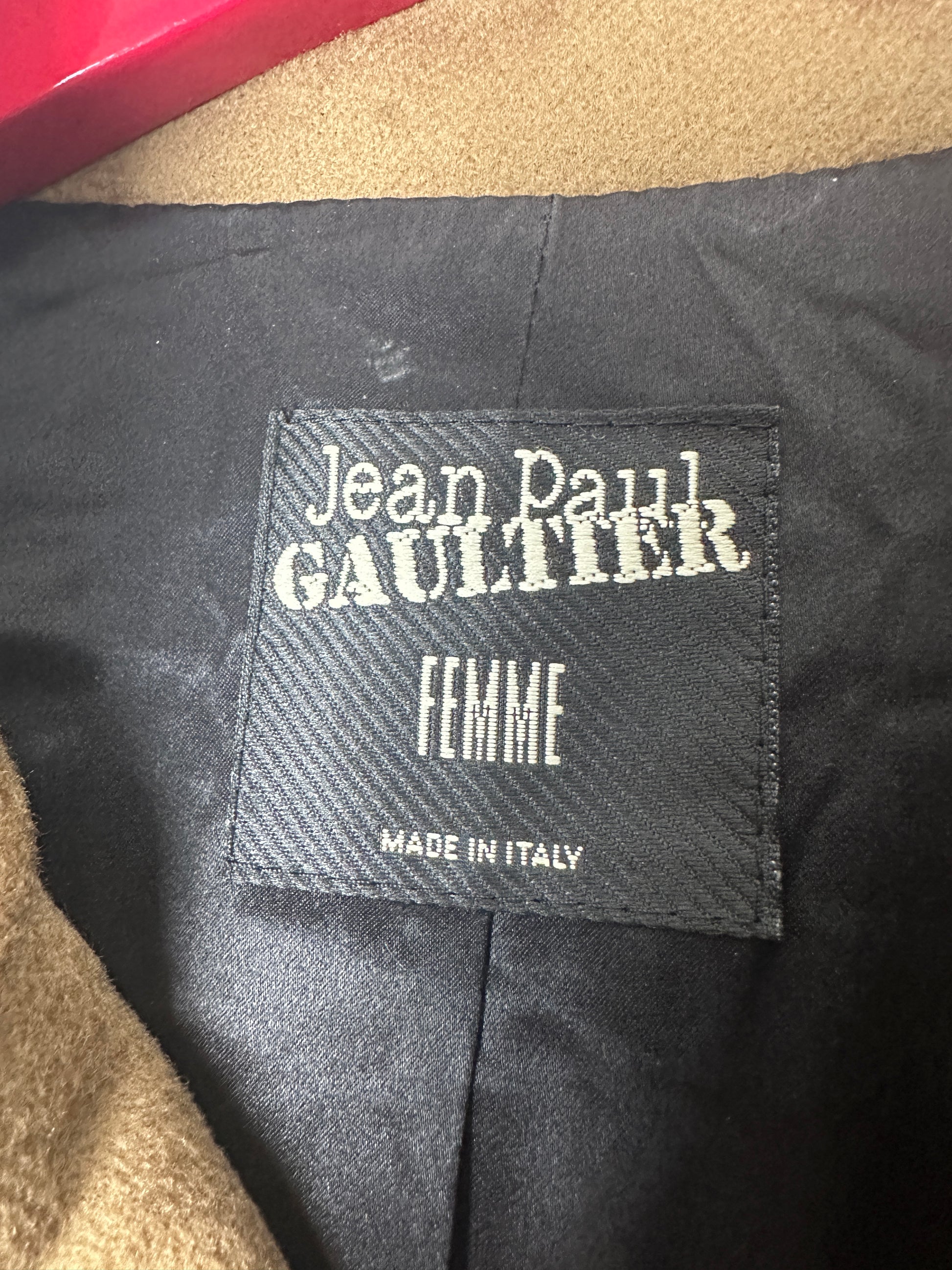 Close-up of a Jean Paul Gaultier label on a garment with 'Femme' and 'Made in Italy' text.
