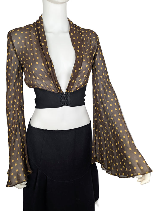 Mannequin wearing a brown polka dot blouse with long sleeves and a black corset-style waistband