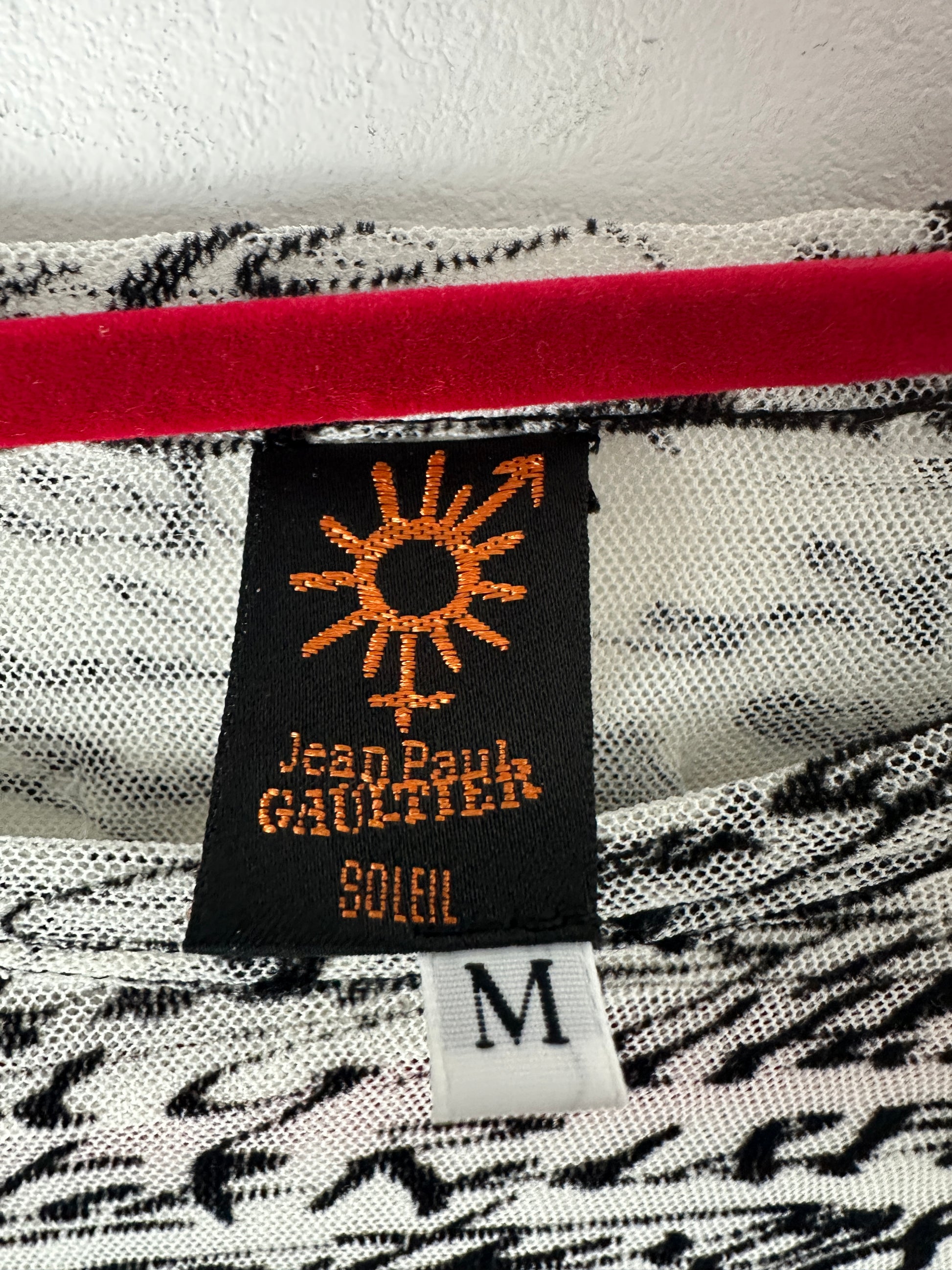 Close-up of a Jean Paul Gaultier label on a garment with a zebra print pattern.
