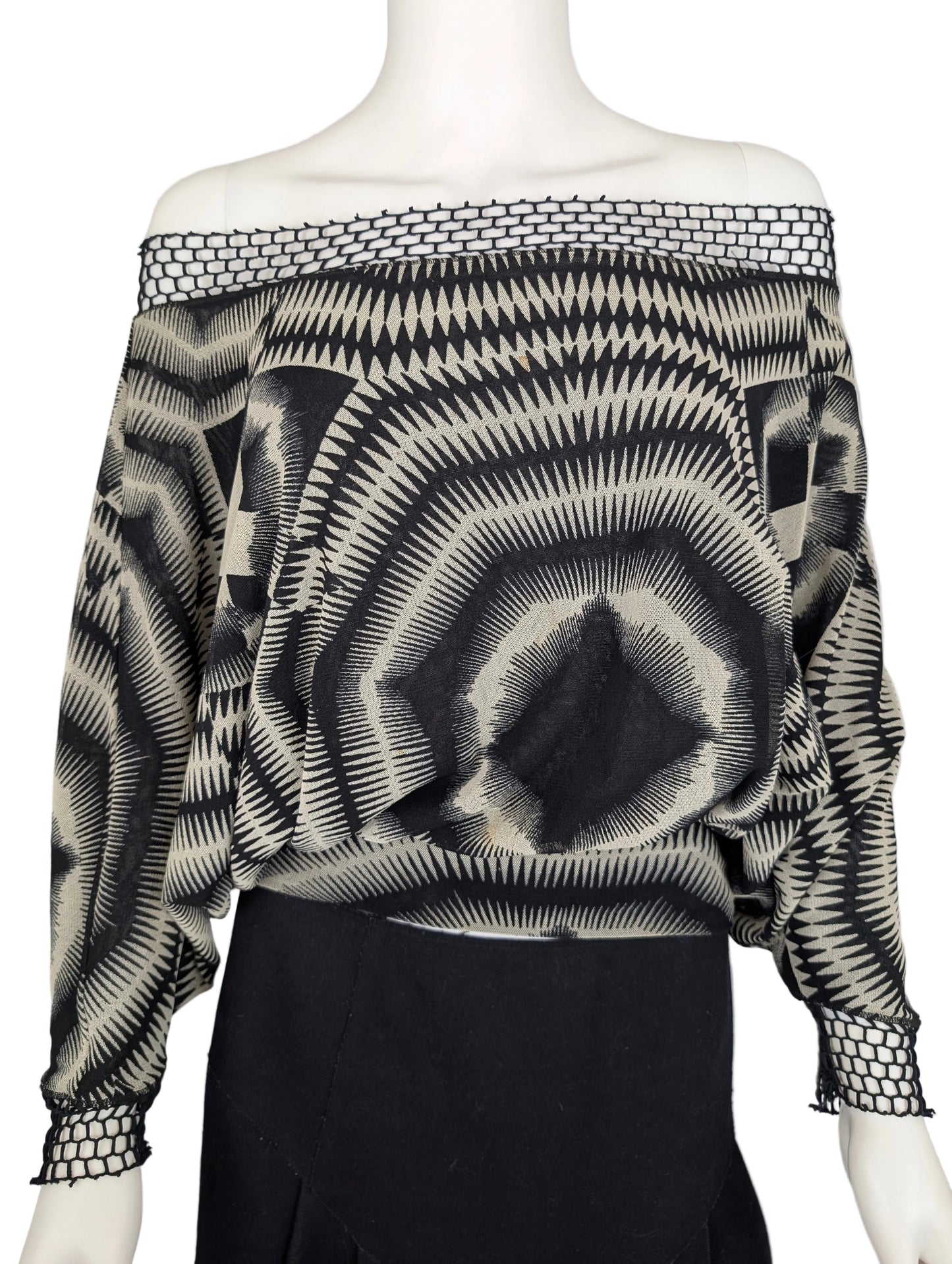 Black and white patterned off-shoulder top on a mannequin against a gray background
