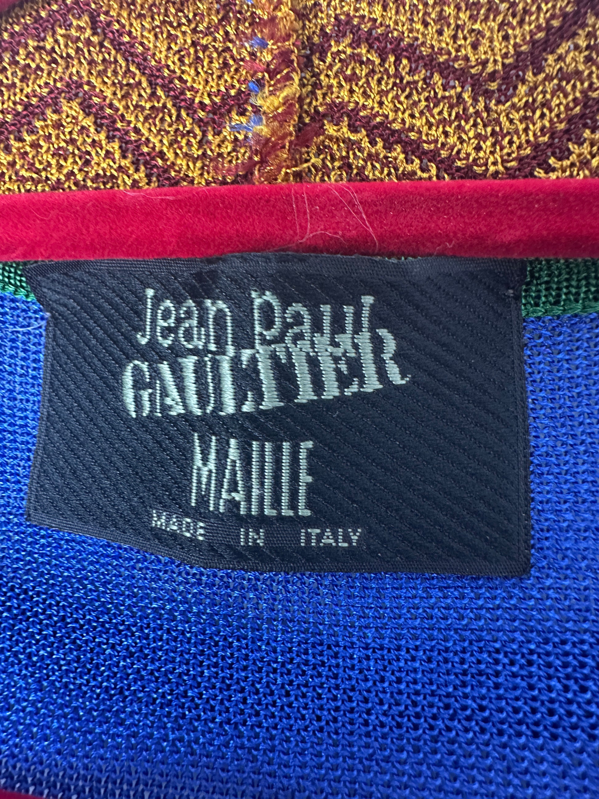 Close-up of a Jean Paul Gaultier label on colorful fabric.