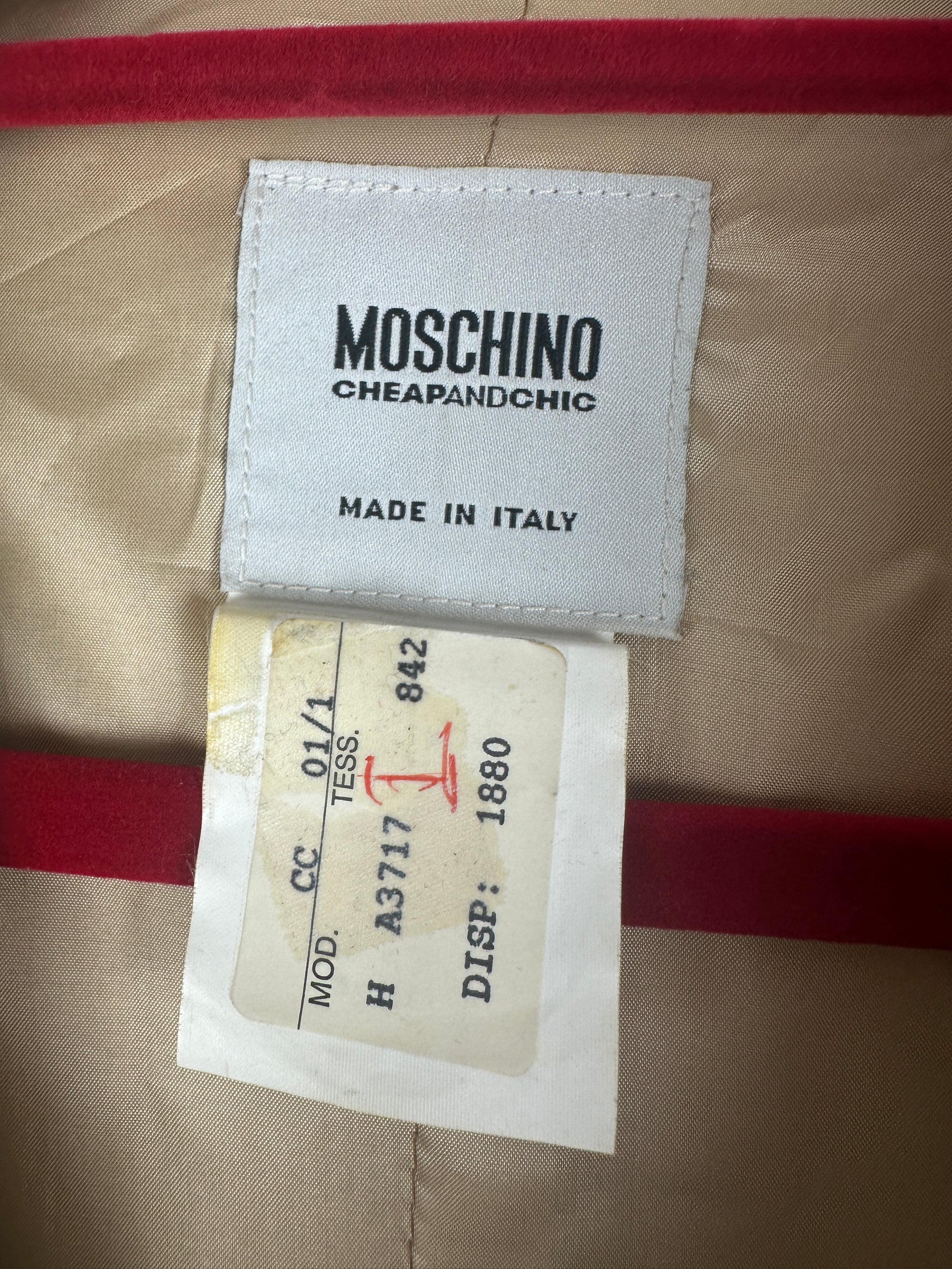 Moschino label on a garment with red and beige stripes