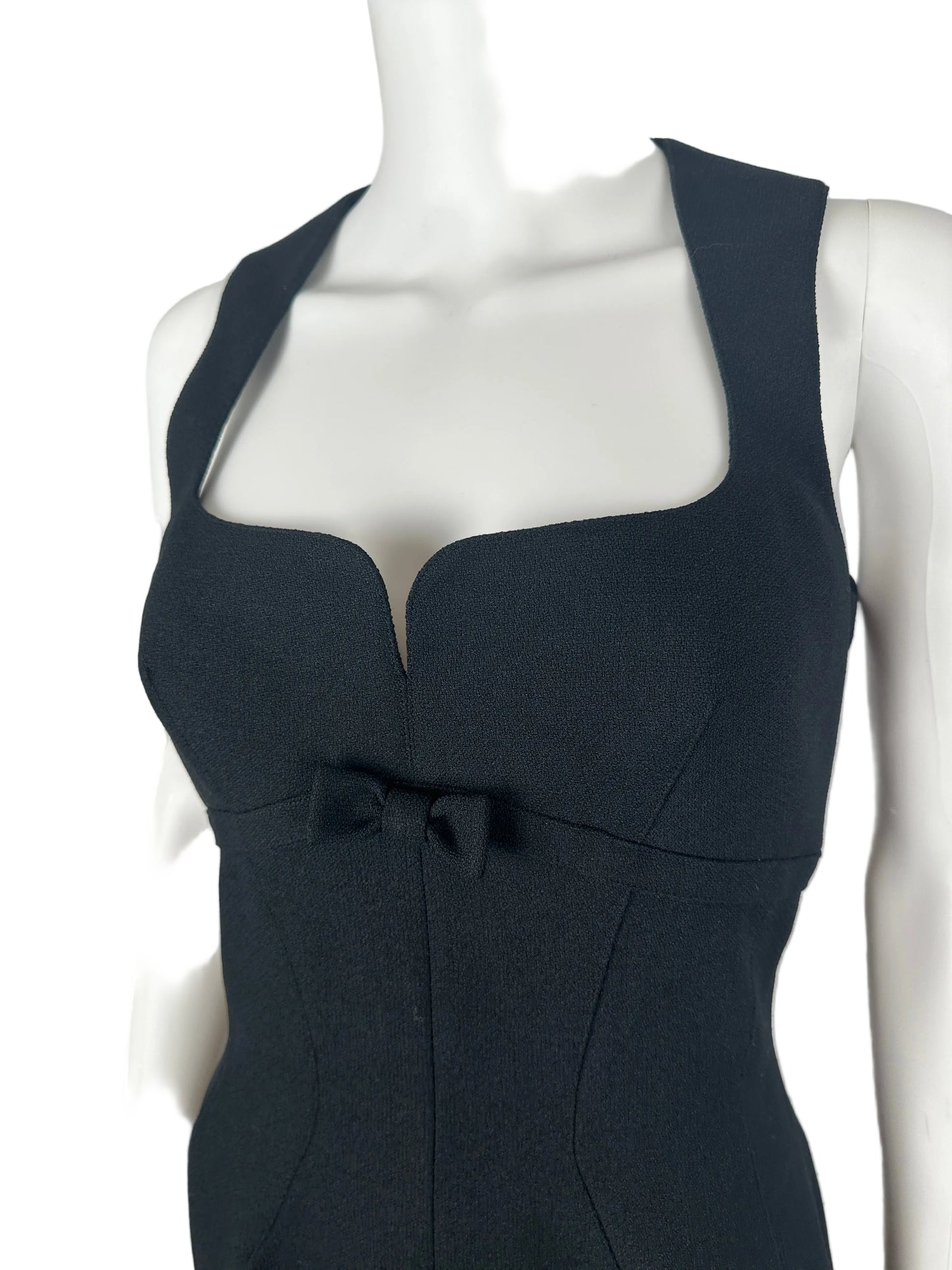 Black dress on a mannequin against a plain background
