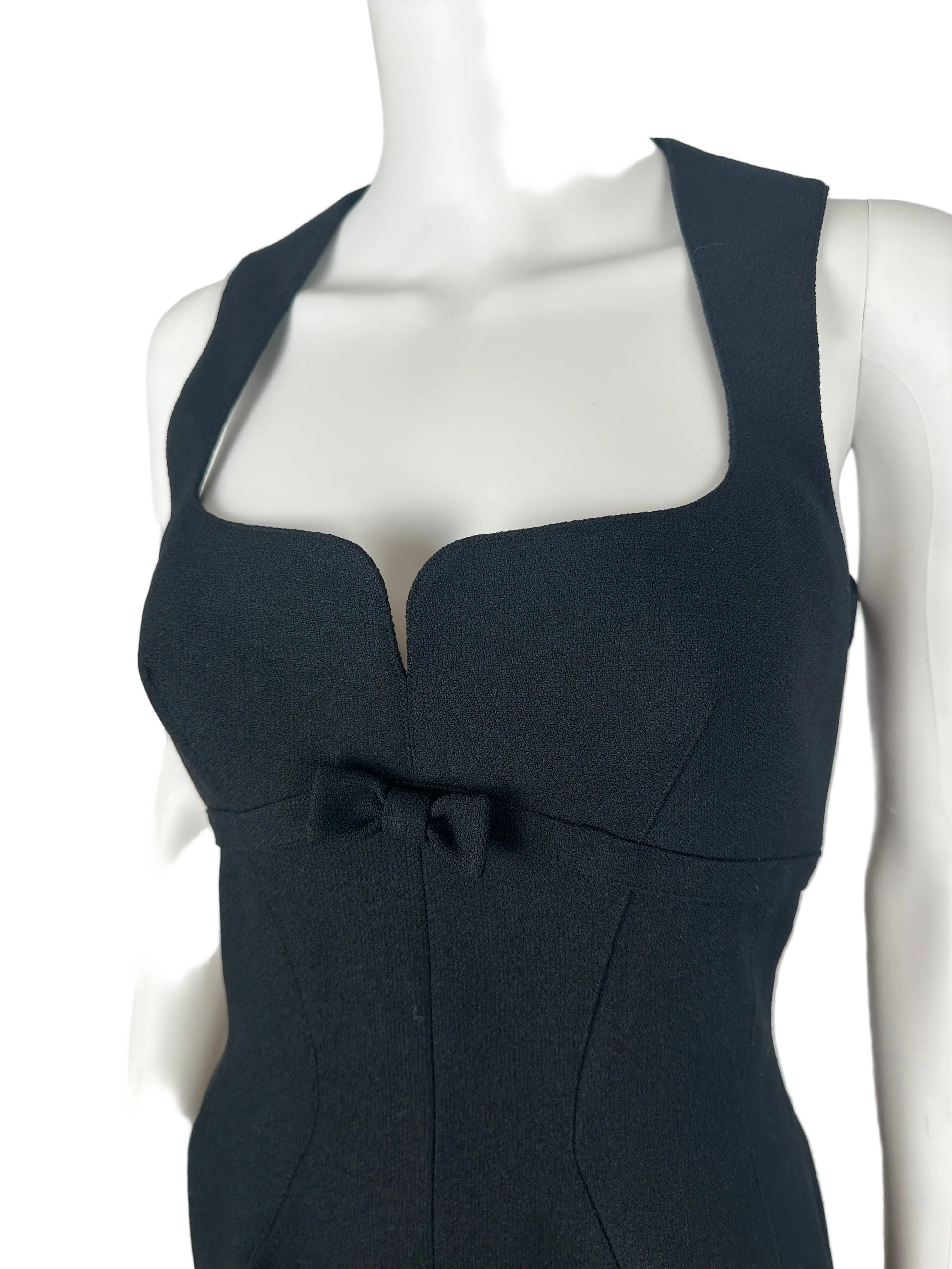 Black dress on a mannequin against a plain background