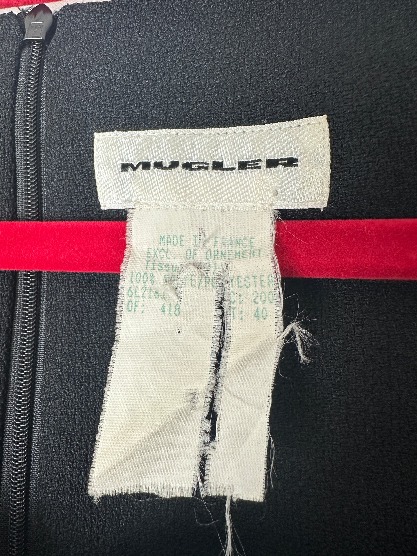 Close-up of a brand label on a black garment with red accents.