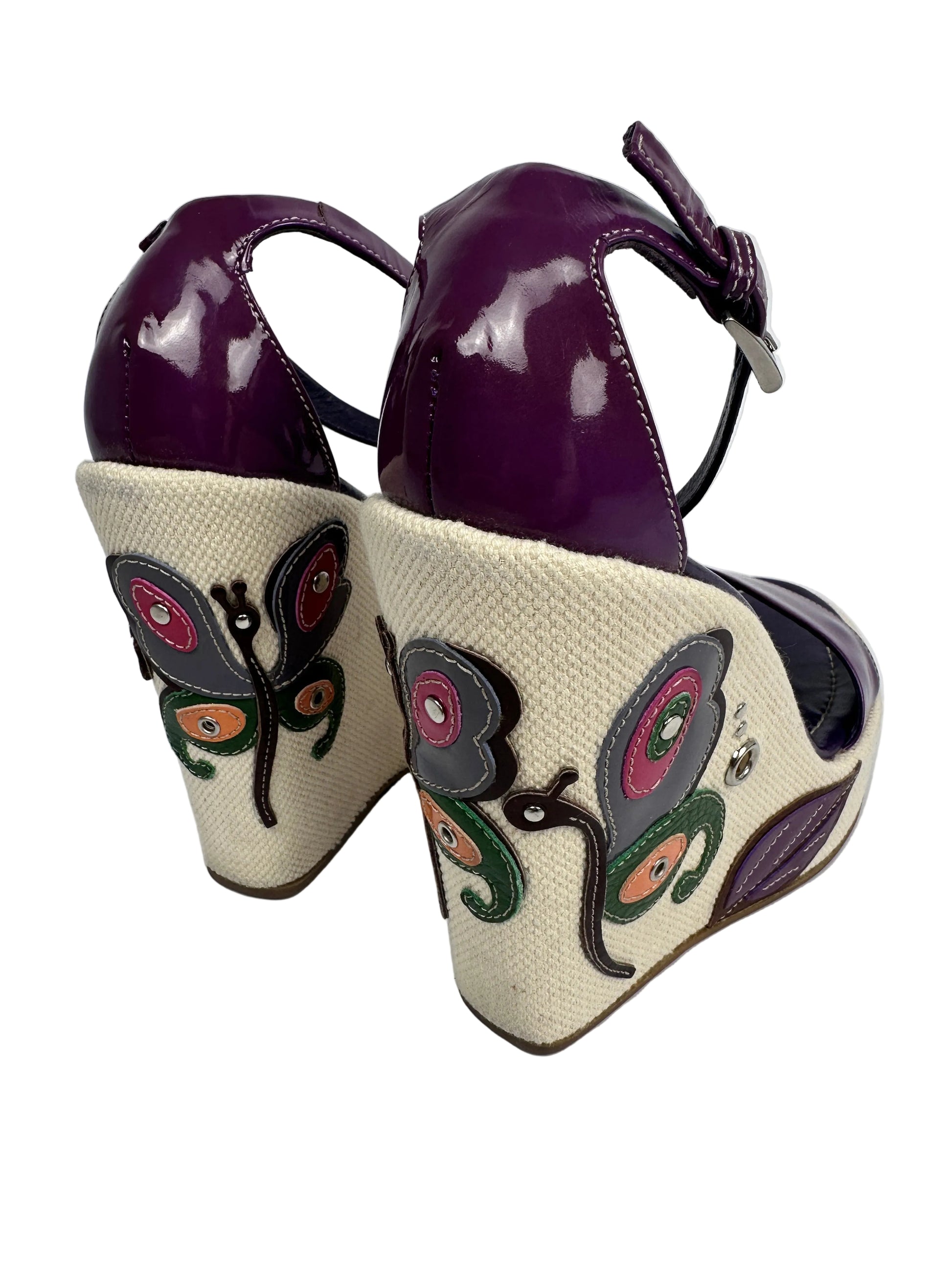 Purple high-heeled shoes with floral patterns on a white background