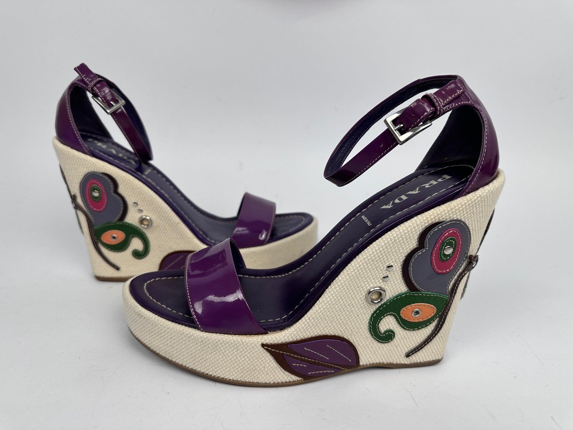Wedge sandals with floral designs on a white background