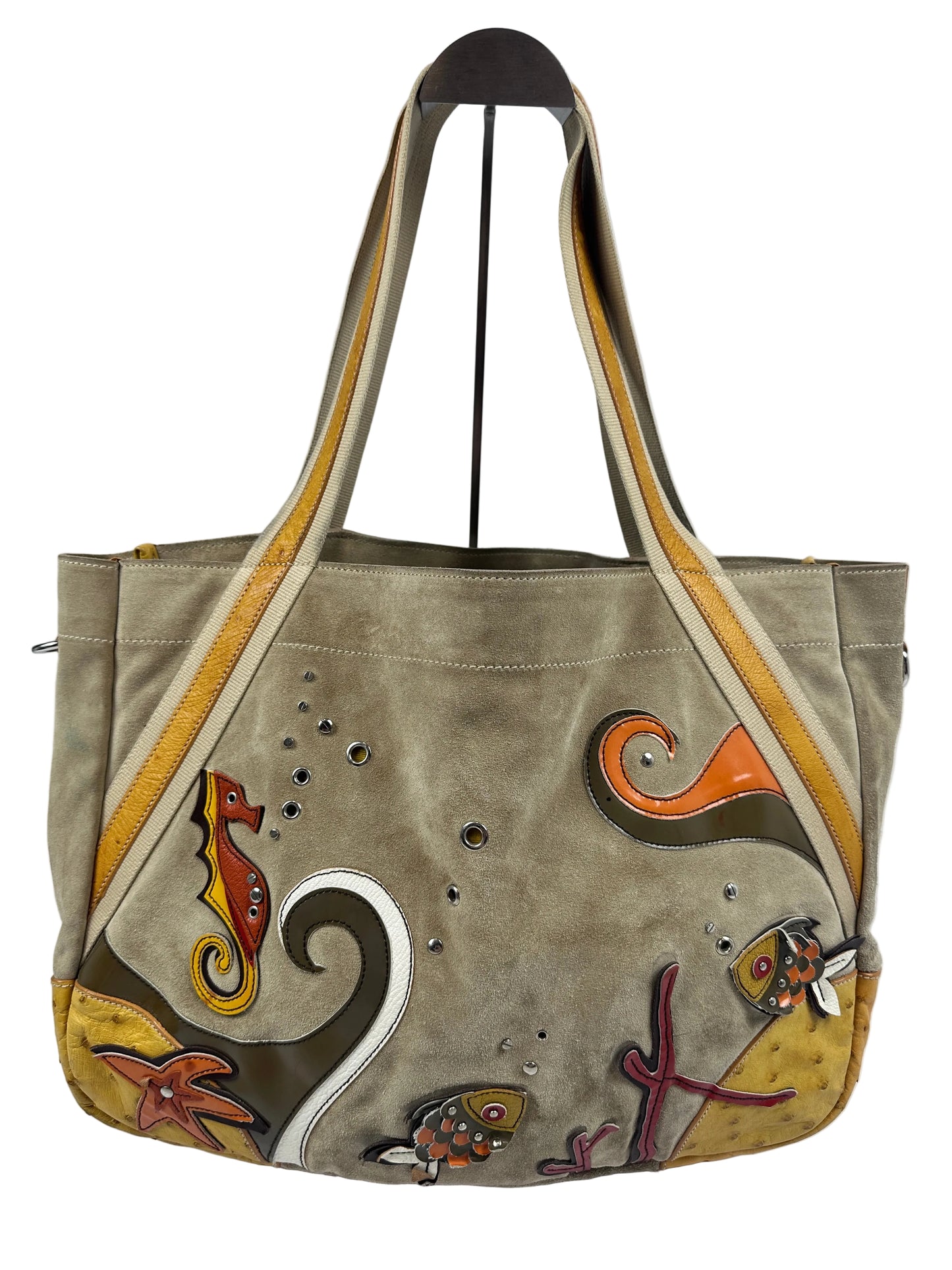 A taupe suede shoulder bag with hand-painted sea life motifs, including a turtle, starfish, and fish, in orange, yellow, brown, and white. The bag features a wide shoulder strap with beige and yellow stripes and is photographed against a plain light gray background.