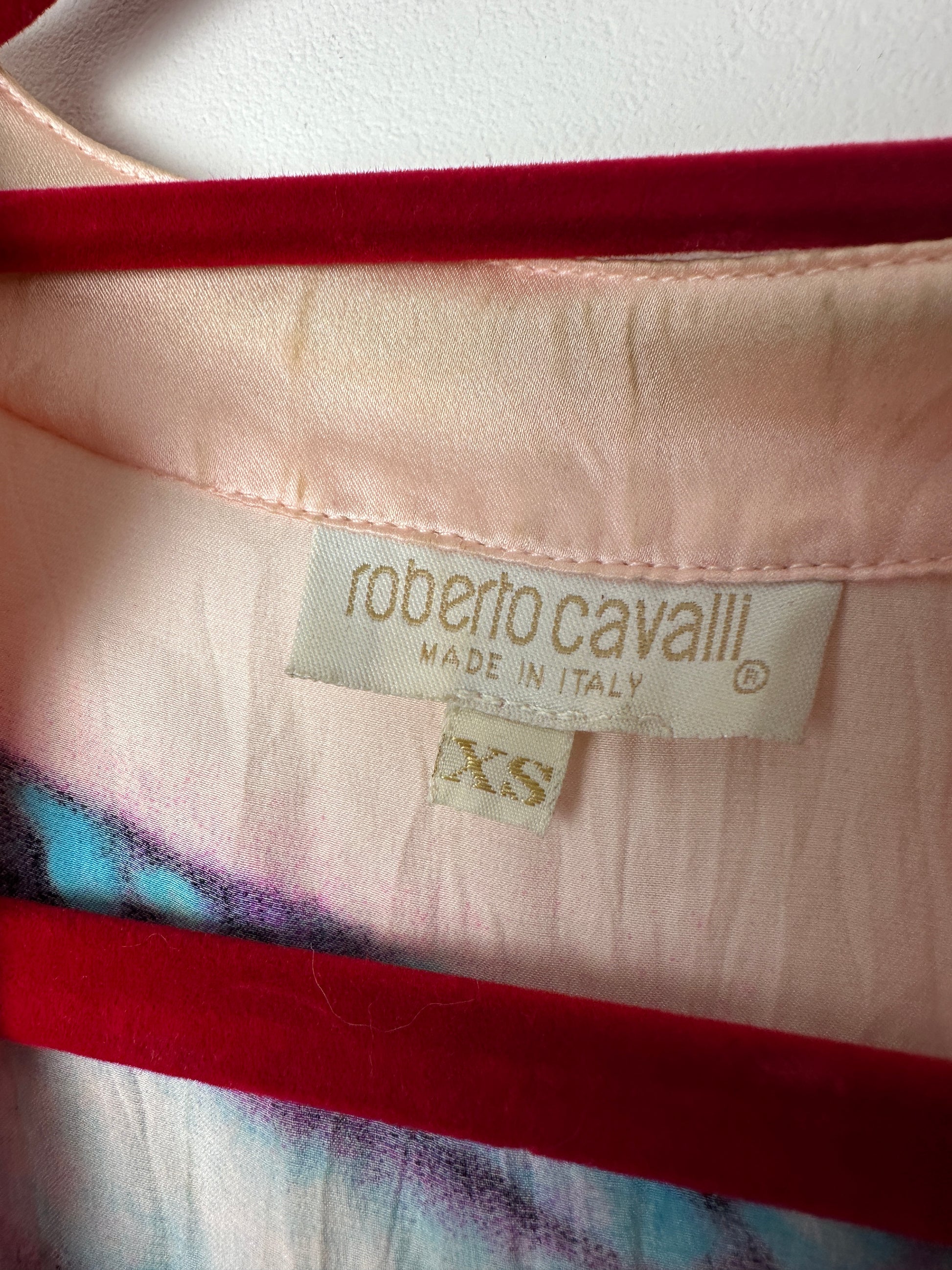 Close-up of a Roberto Cavalli label on a garment with red and multicolor pattern.