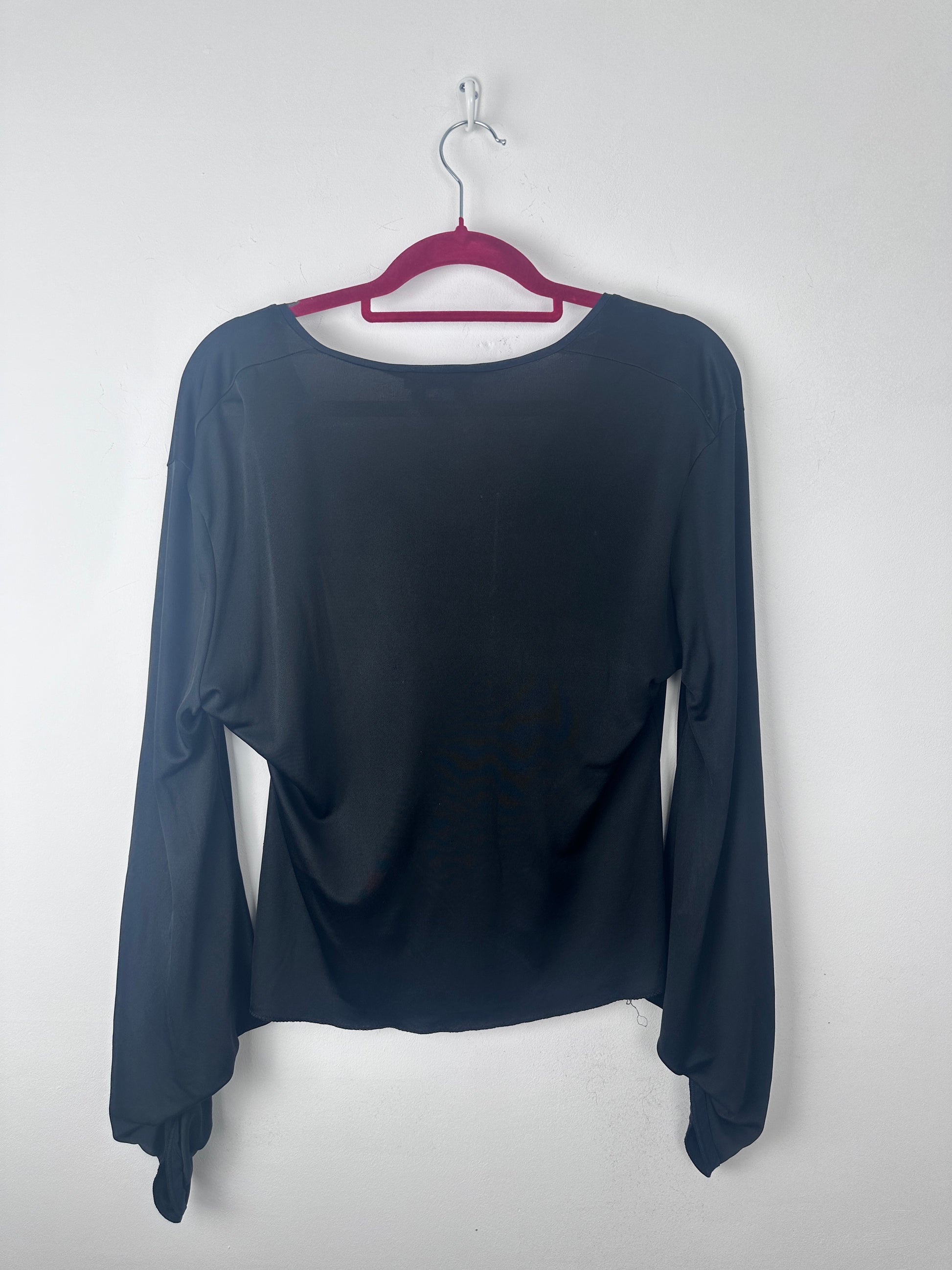 A dark navy blue long-sleeve top hanging on a magenta hanger against a plain white background.