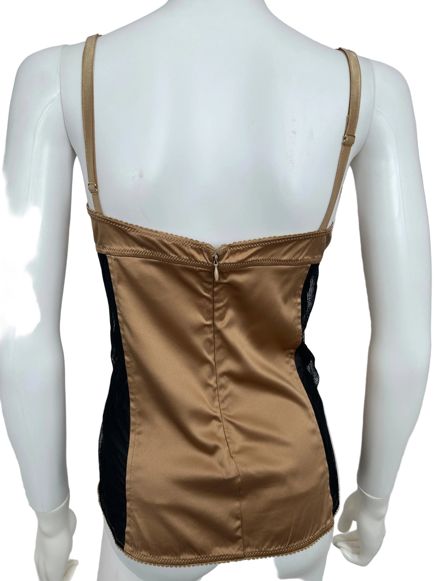 Mannequin wearing a beige satin garment with a black lining on a white background