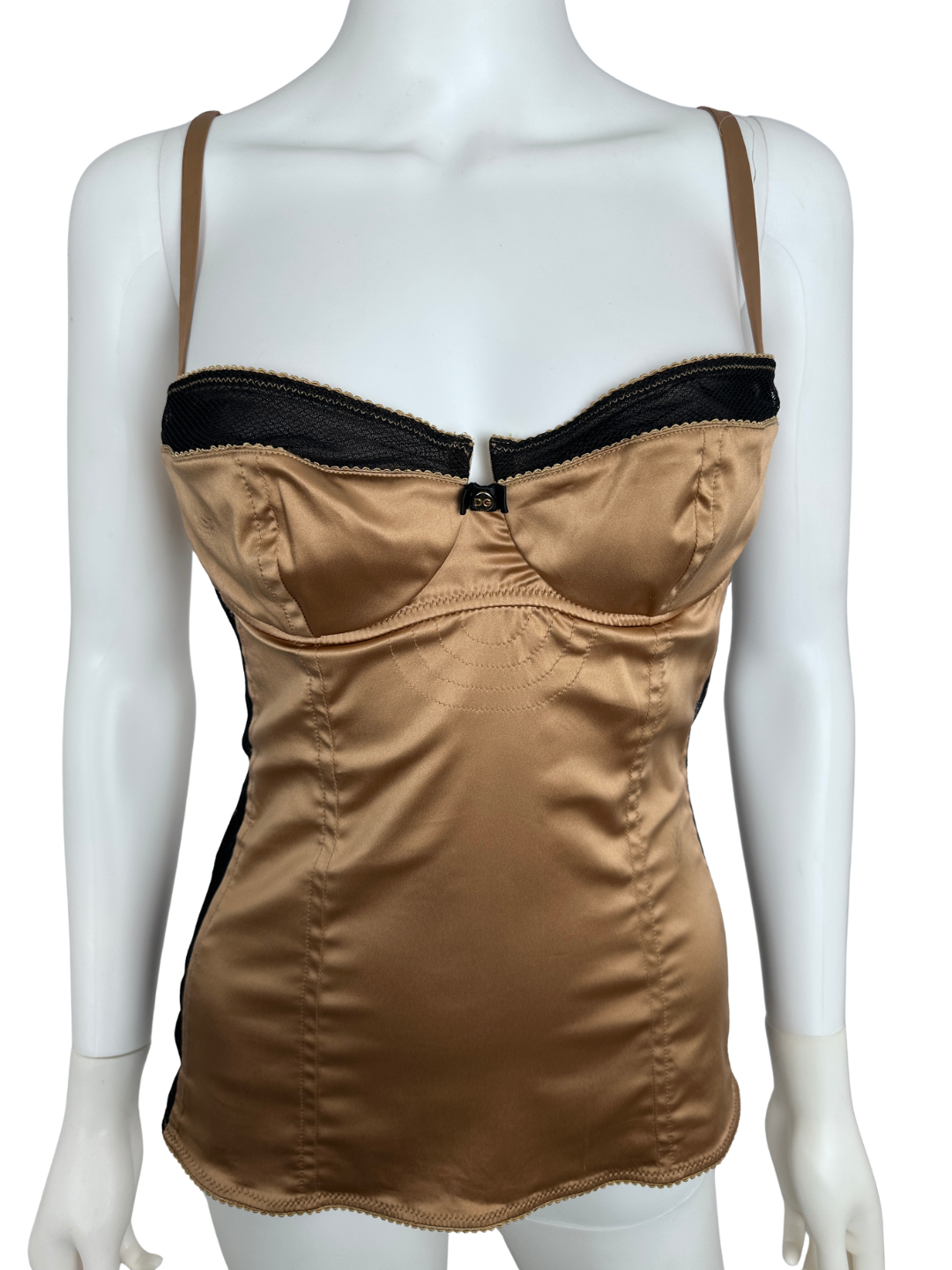 Mannequin wearing a brown top with black lining on a white background
