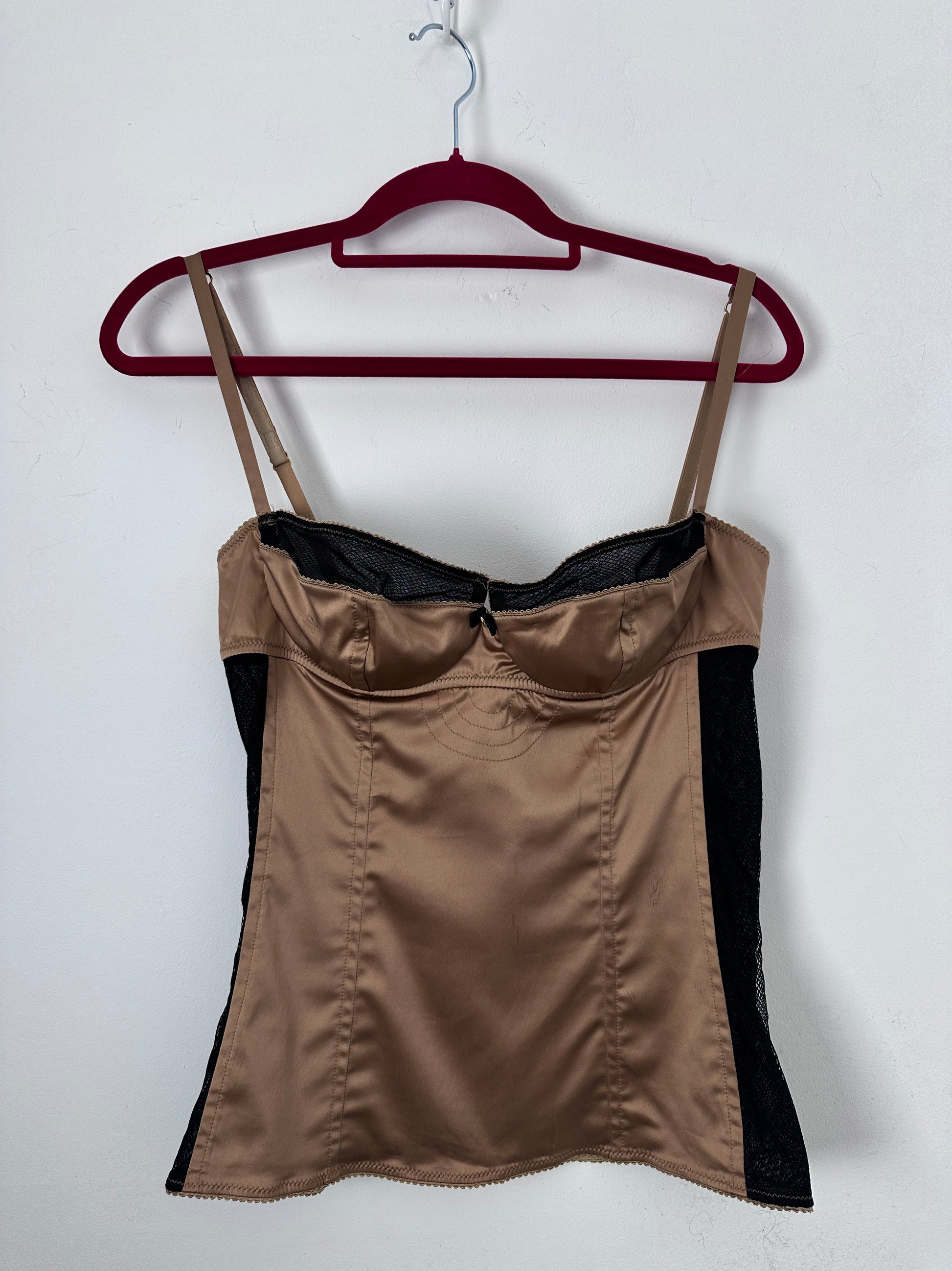 Brown corset with black accents on a red hanger against a white background