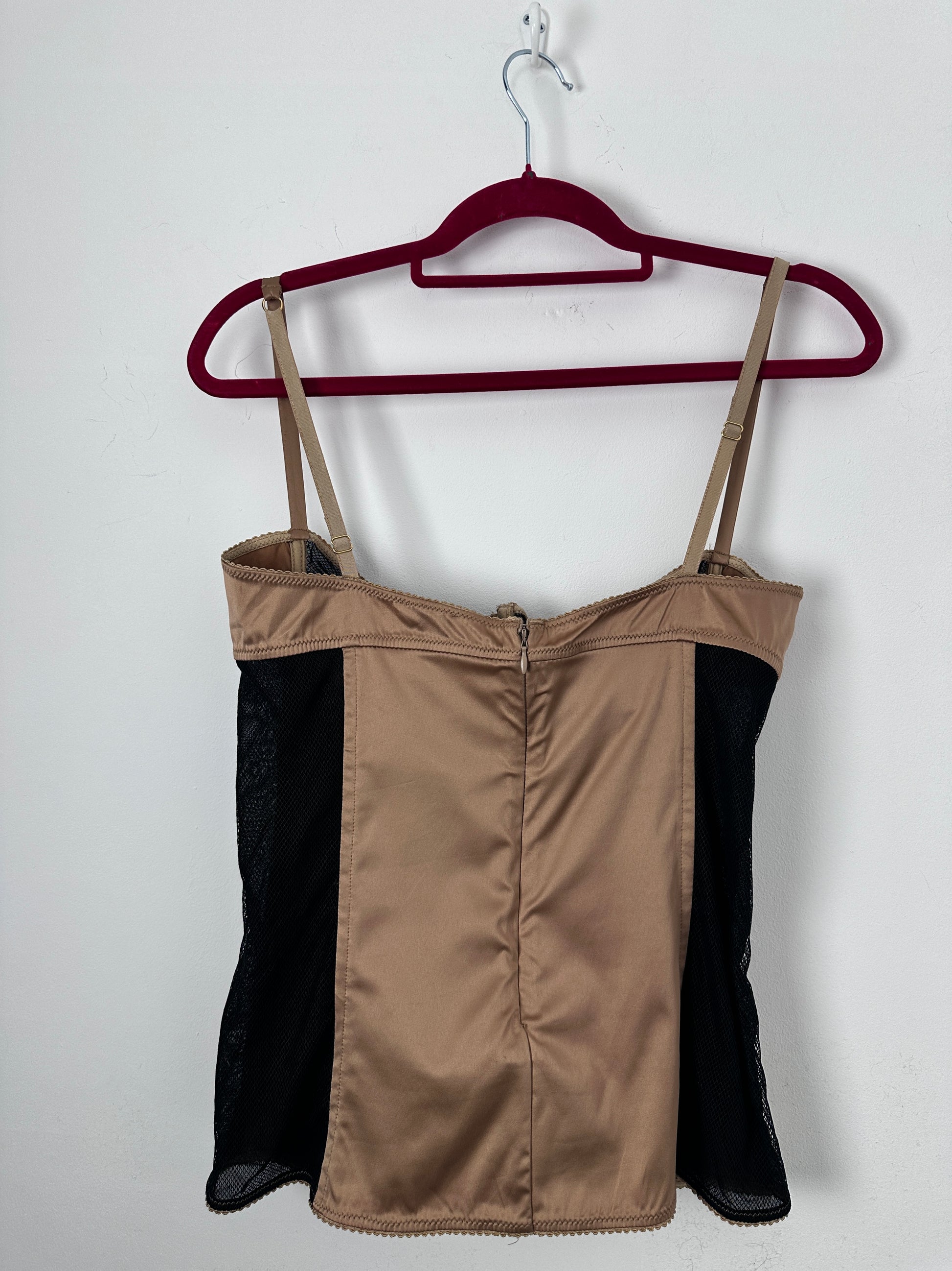Brown and black corset on a hanger against a white background