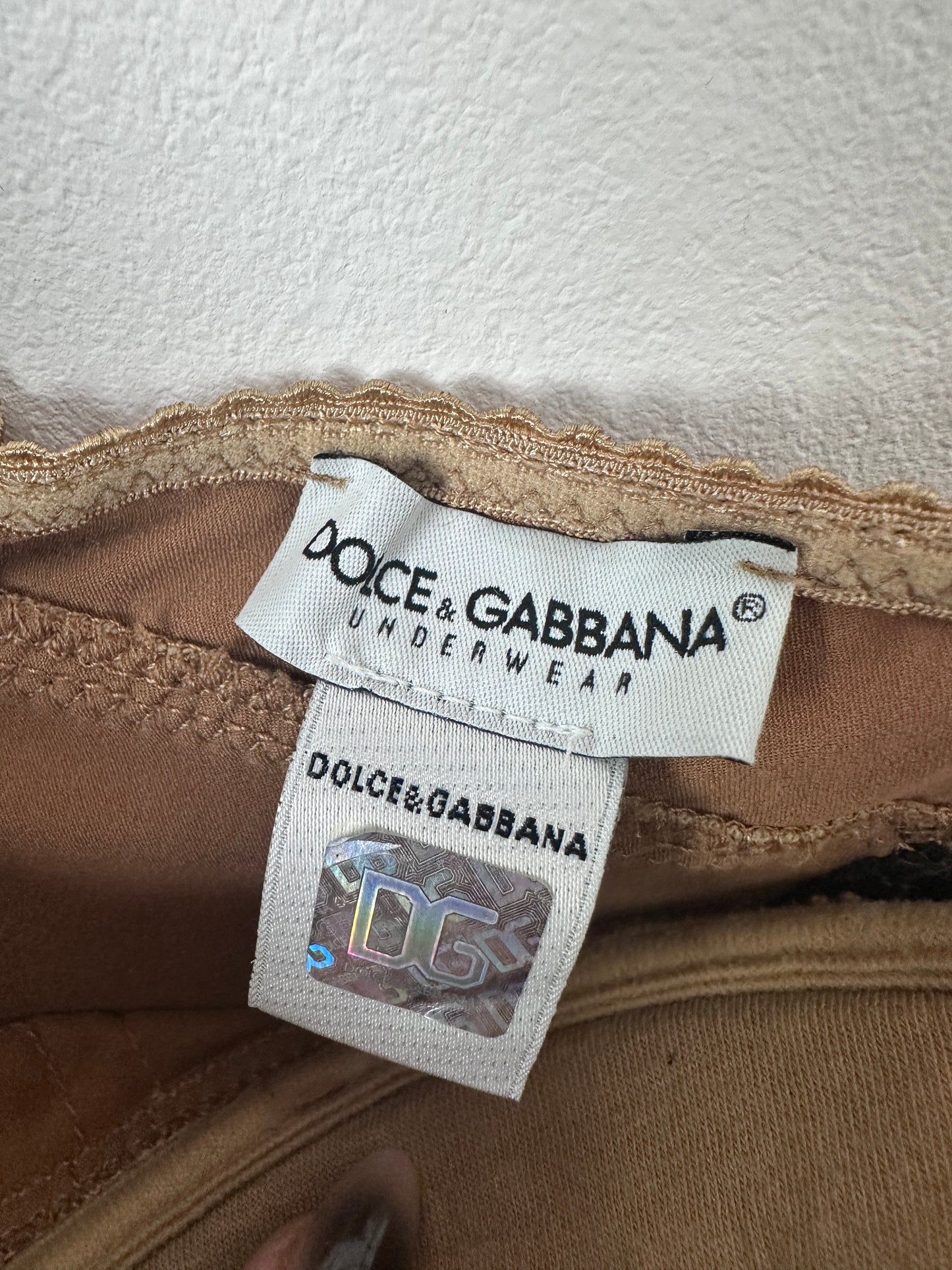 Dolce & Gabbana underwear tag on a brown fabric background