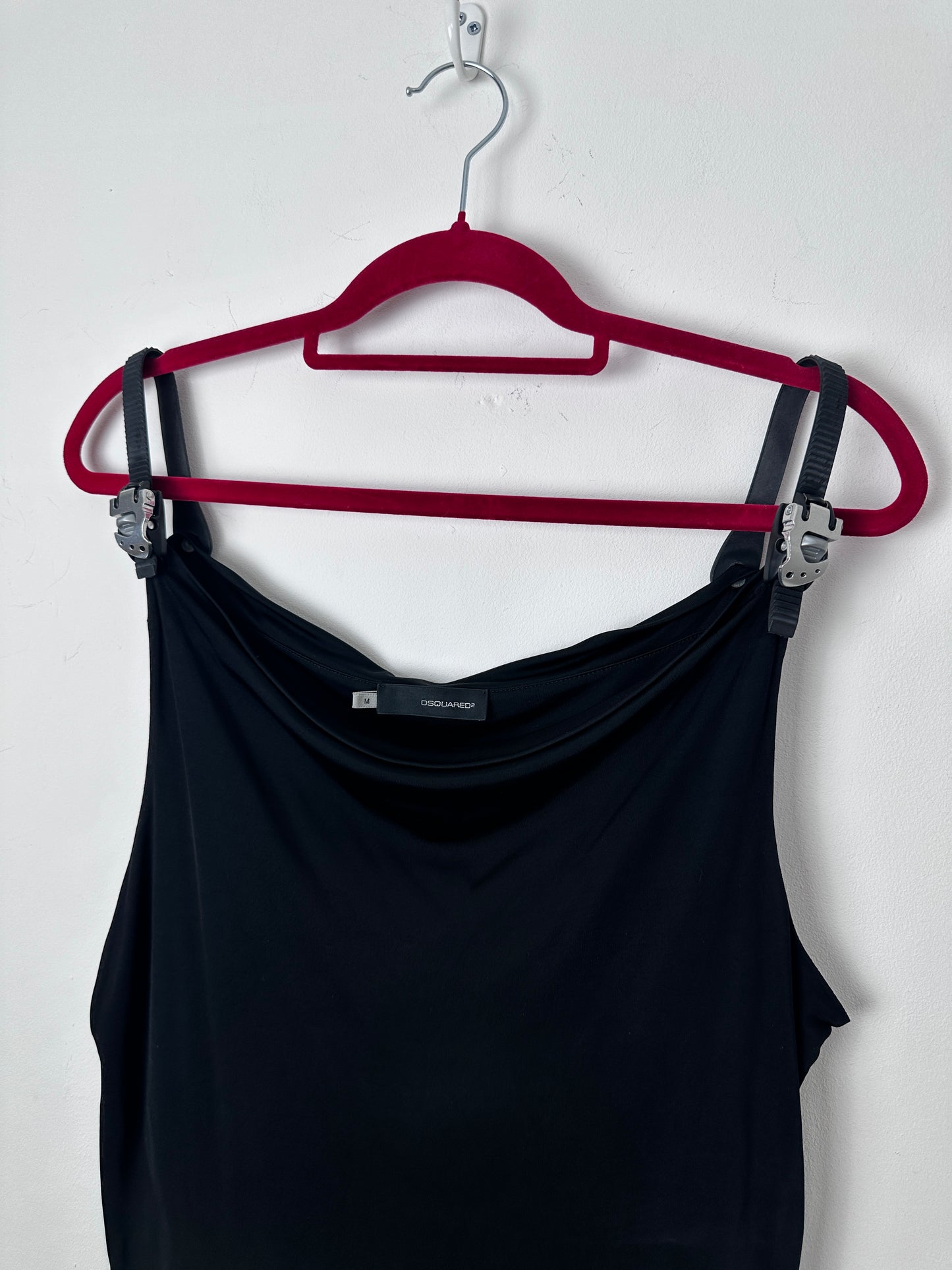 A black sleeveless top or dress displayed on a red hanger against a plain white background.