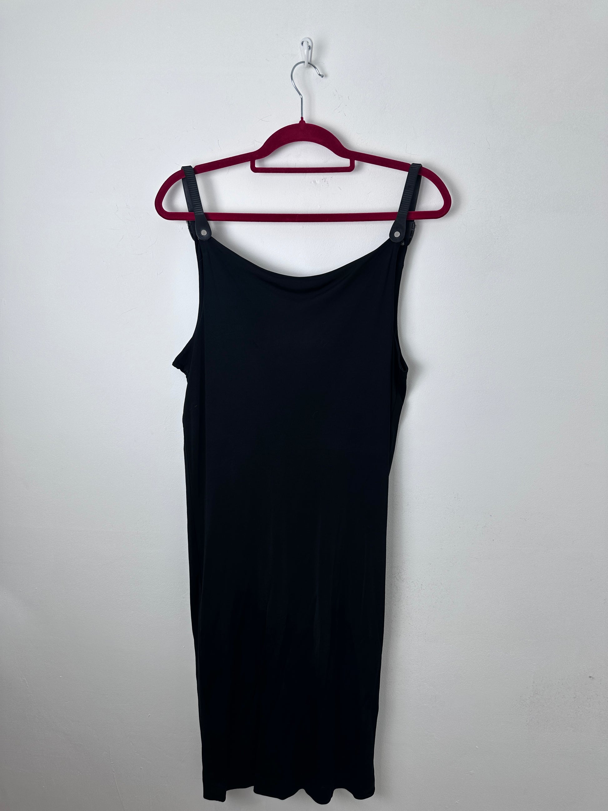A black sleeveless tank top hanging flat on a dark red hanger against a plain white background.