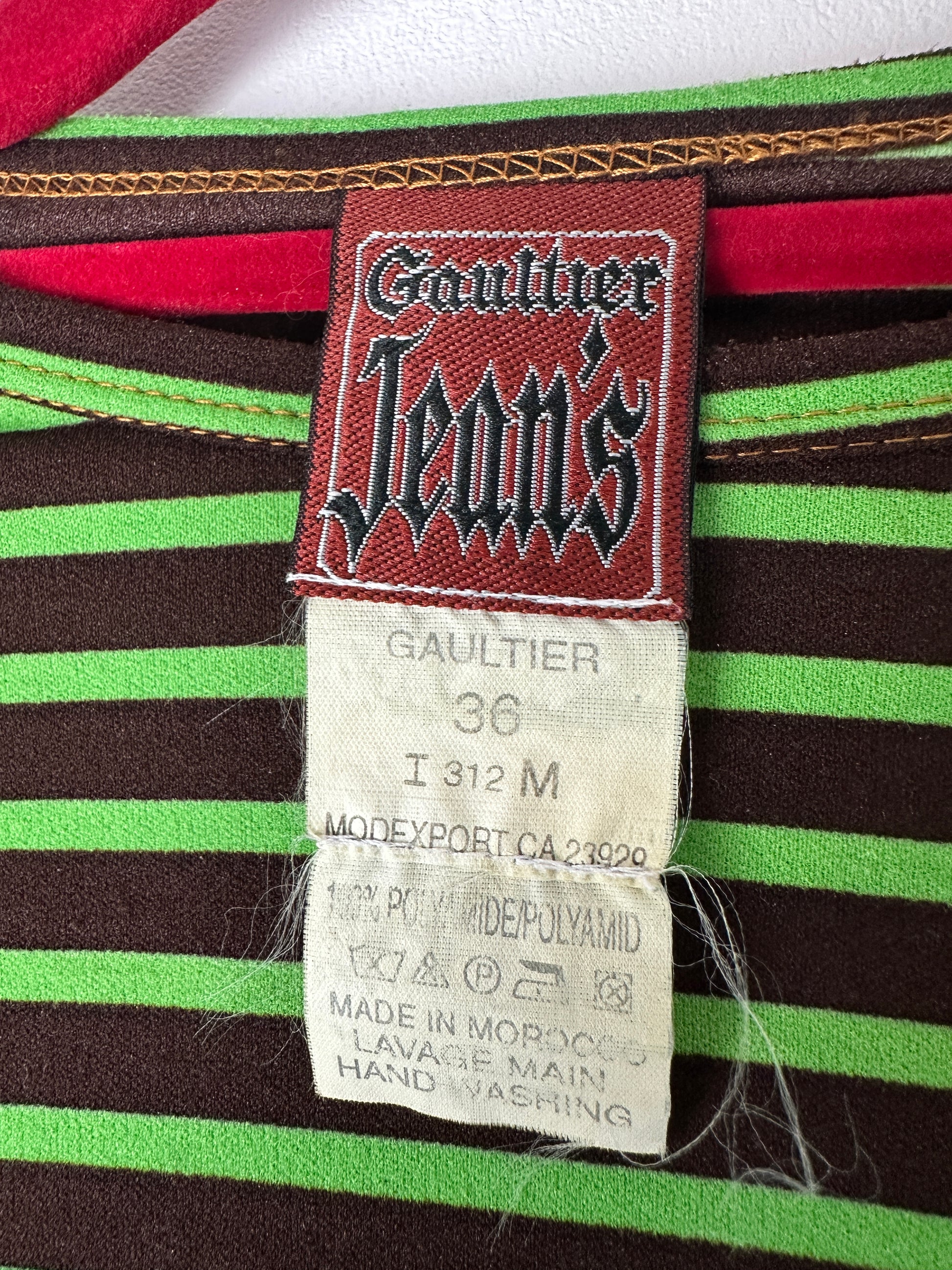 Close-up of a striped fabric with a Gaultier Jeans label on a multicolored background