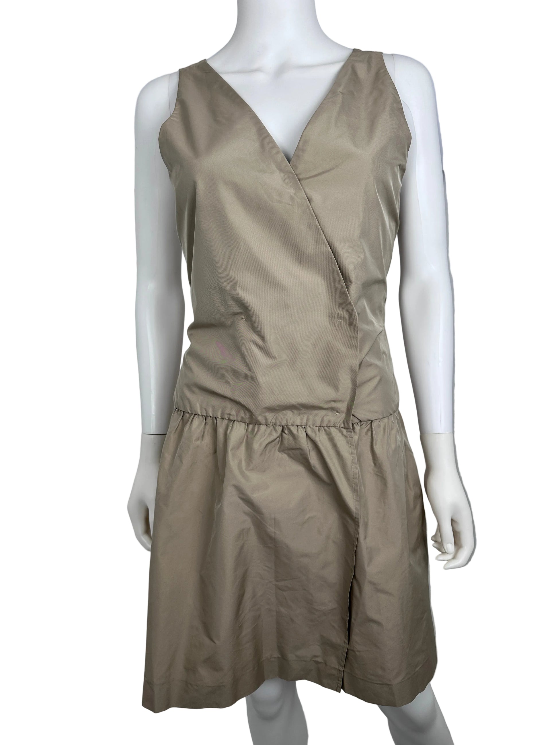 Mannequin wearing a beige dress against a plain background