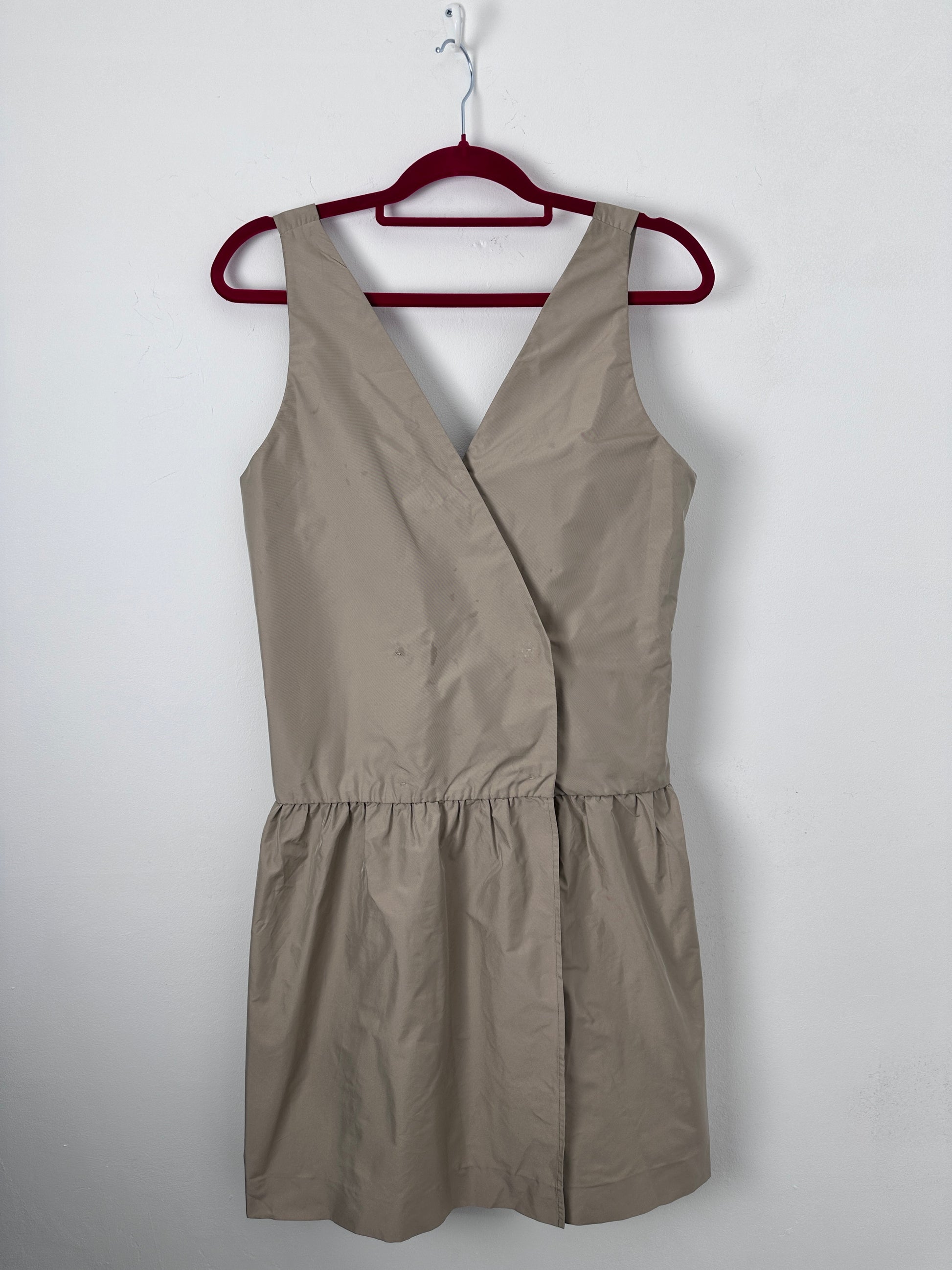 Beige dress on a red hanger against a white background